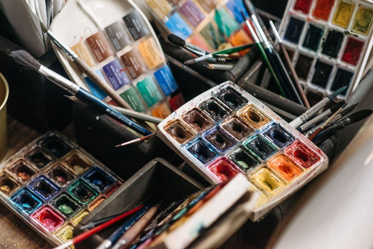 A colorful array of watercolor paints and brushes perfect for creative art projects.
