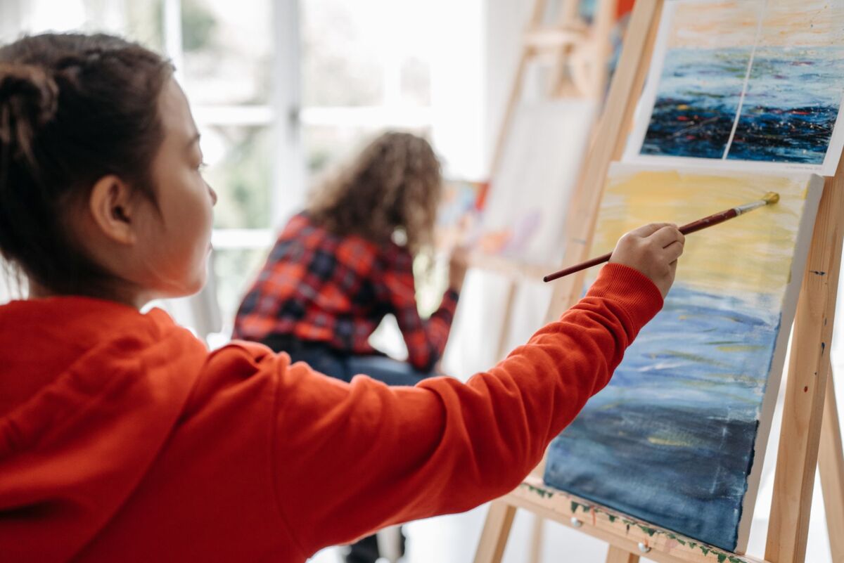 Children painting on easels in a vibrant classroom setting, enhancing creativity and learning.