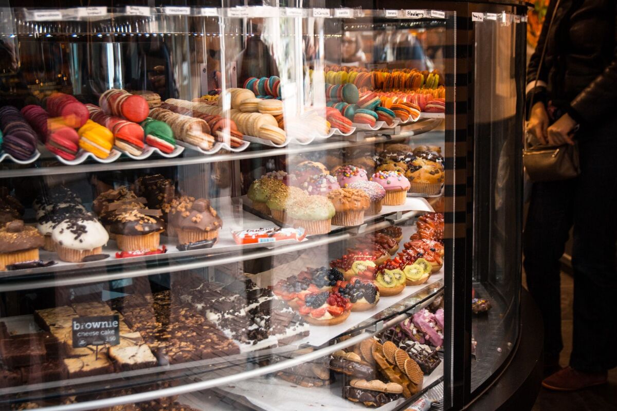 Delicious assortment of macarons and cupcakes in a showcase at a Brussels bakery.