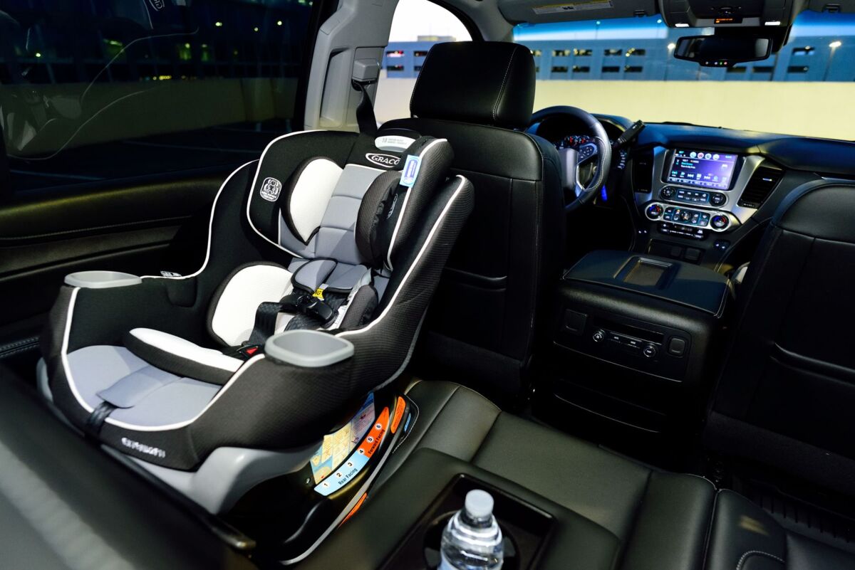 Interior of a car featuring a child safety seat and illuminated dashboard, captured at night.