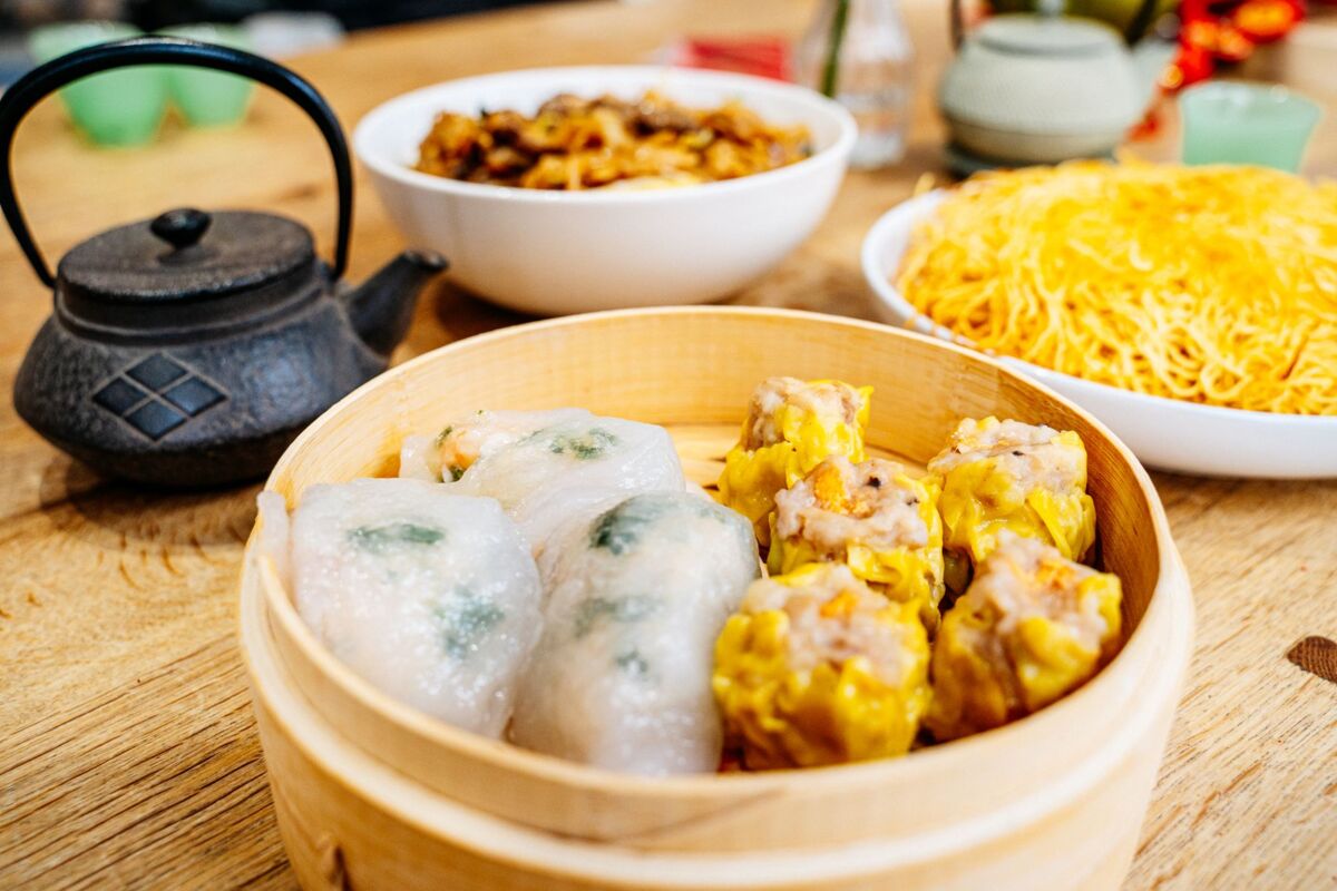 A tempting assortment of dim sum dishes accompanied by a traditional Chinese tea set, perfect for Lunar New Year celebrations.