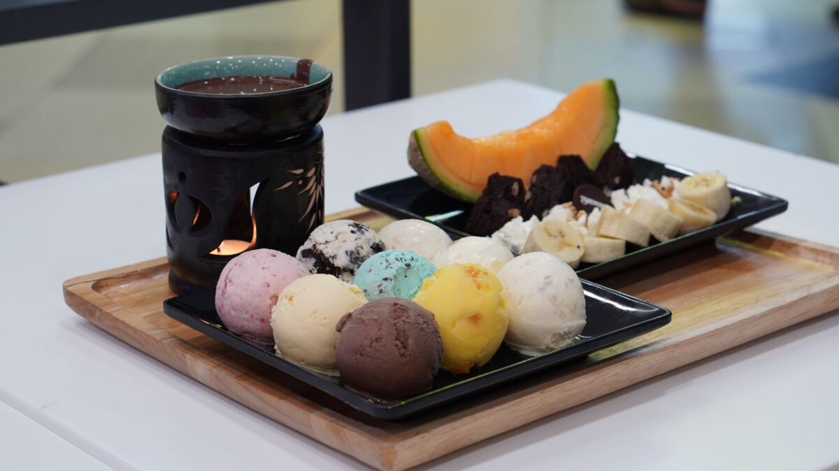 A vibrant dessert platter featuring assorted ice cream, fruits, and hot chocolate for a delightful treat.