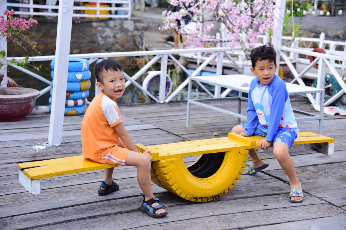 Two children playing on a colorful seesaw outdoors. Fun and joy on a bright sunny day.