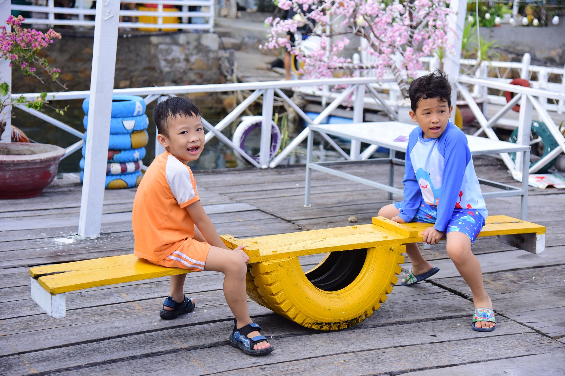 Two children playing on a colorful seesaw outdoors. Fun and joy on a bright sunny day.