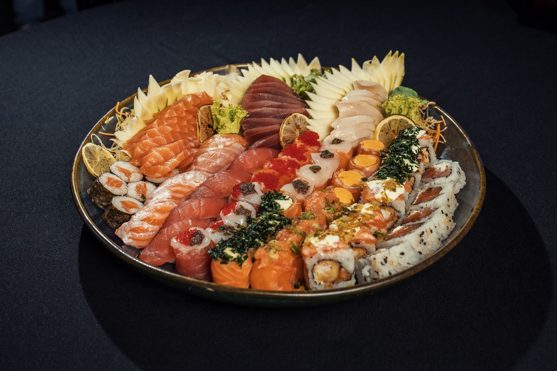 A vibrant sushi platter showcasing various types of sashimi and rolls, beautifully arranged.