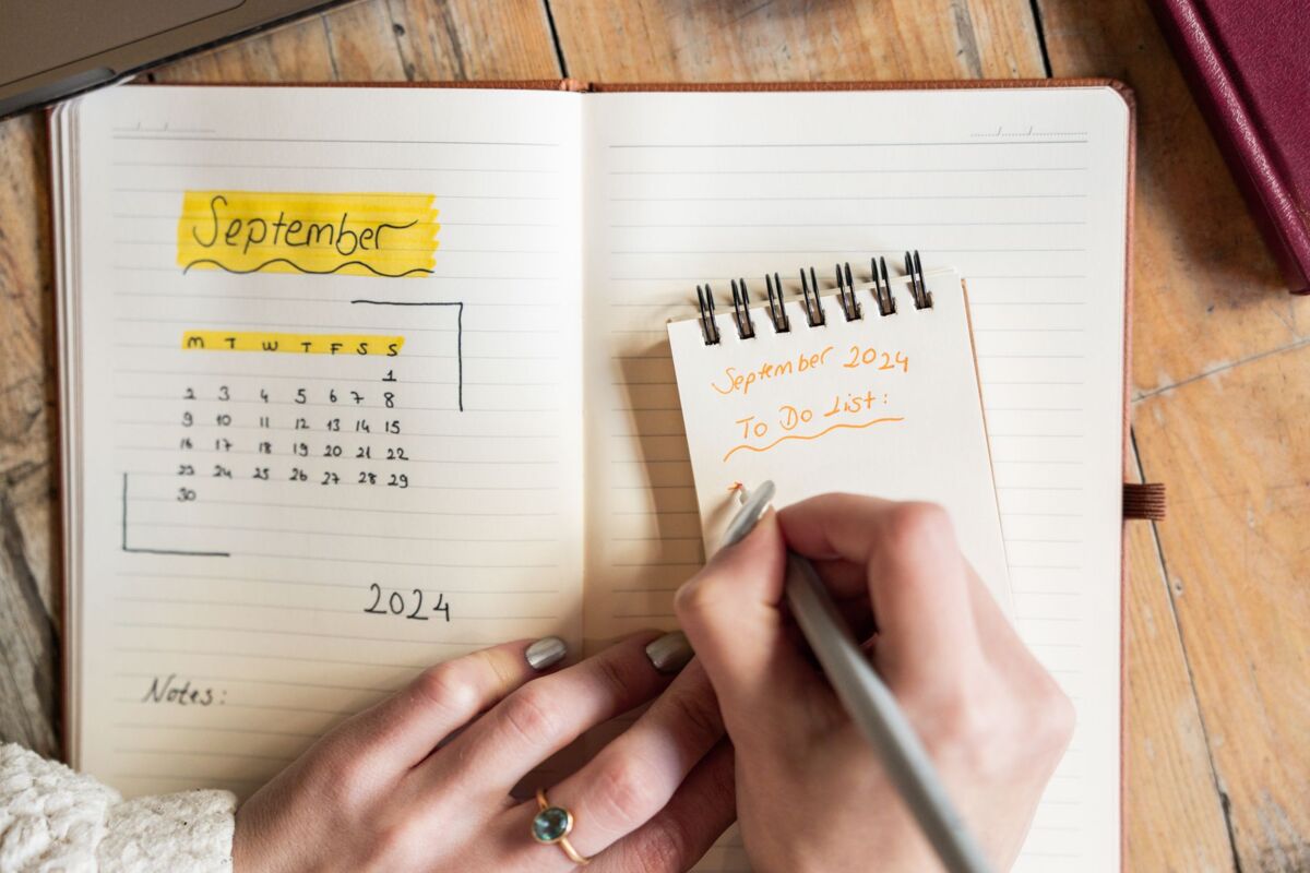Close-up of a woman writing a to-do list in a notebook. Concept of organization.