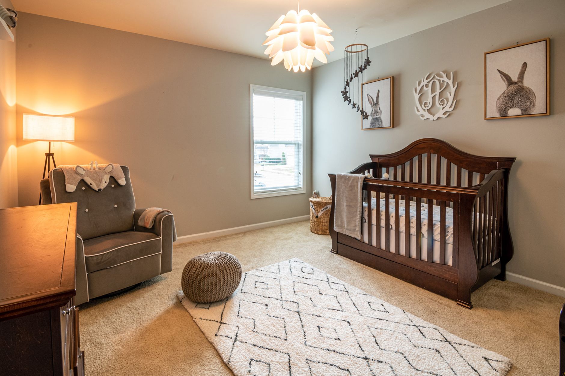 Warm and inviting baby room with elegant crib, armchair, and decor.