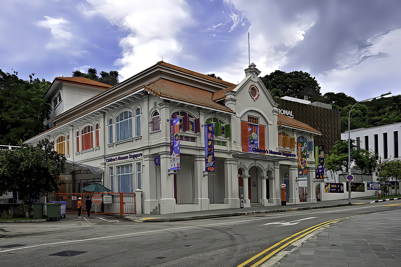 Angled corner view of Children's Museum Singapore showing the colourful banners and restored colonial-era architecture
