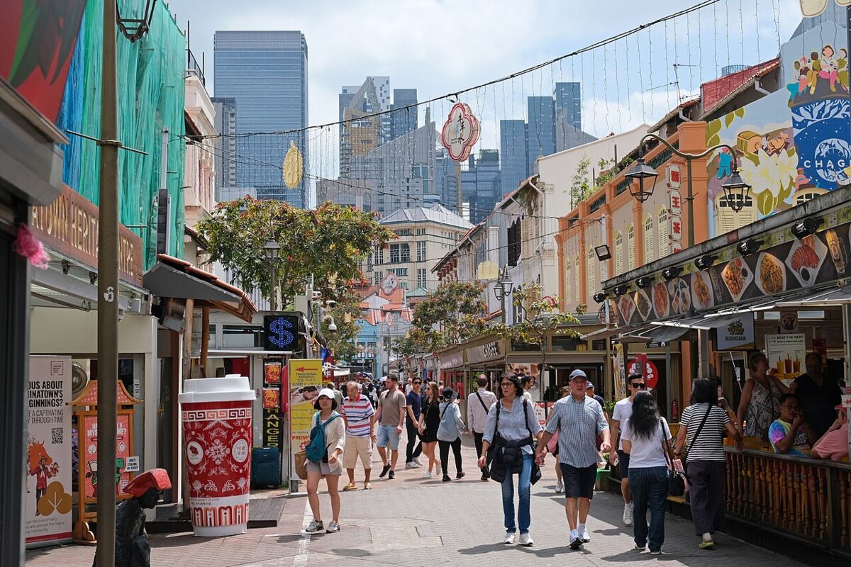 Pedestrian-only Pagoda Street in Chinatown Singapore lined with shophouse stalls and the city skyline behind