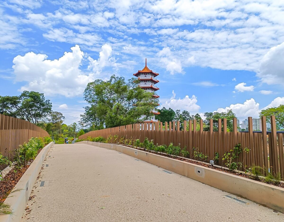 Paved garden pathway leading toward the Chinese Garden pagoda under bright blue skies