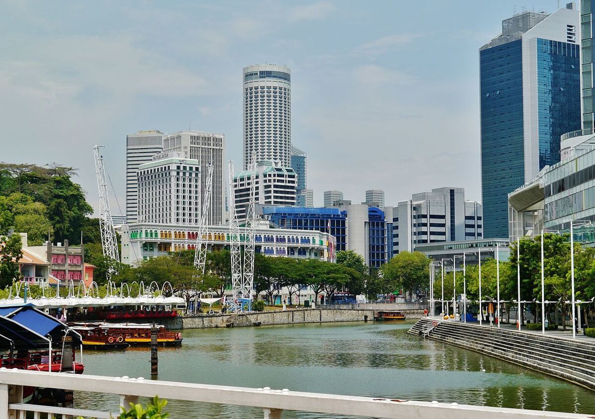Daytime view from Clarke Quay of the Singapore River with moored bumboats and the city skyline behind