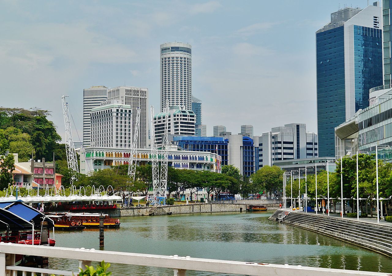 Daytime view from Clarke Quay of the Singapore River with moored bumboats and the city skyline behind