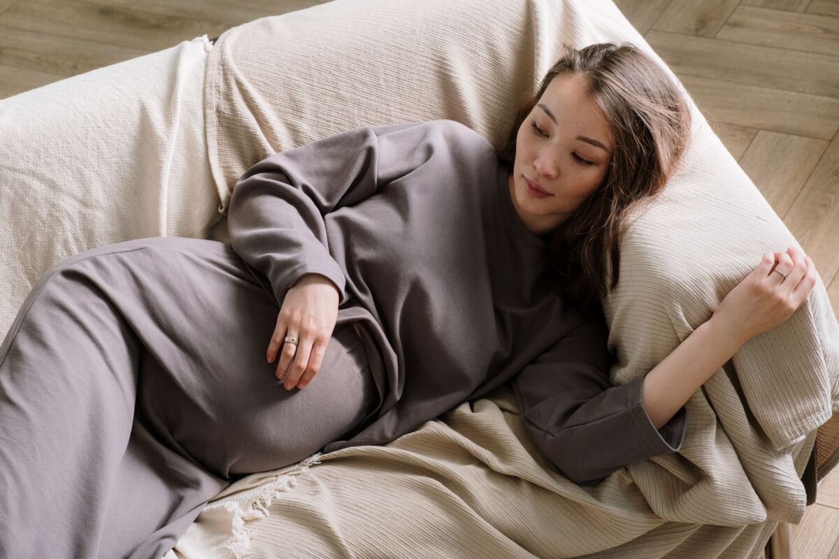 Pregnant woman lying on a comfortable sofa, embracing calm and relaxation