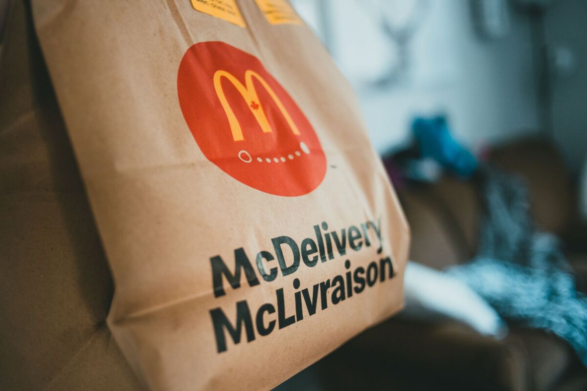 Brown packet with hot fresh food delivered at home on blurred background in daytime