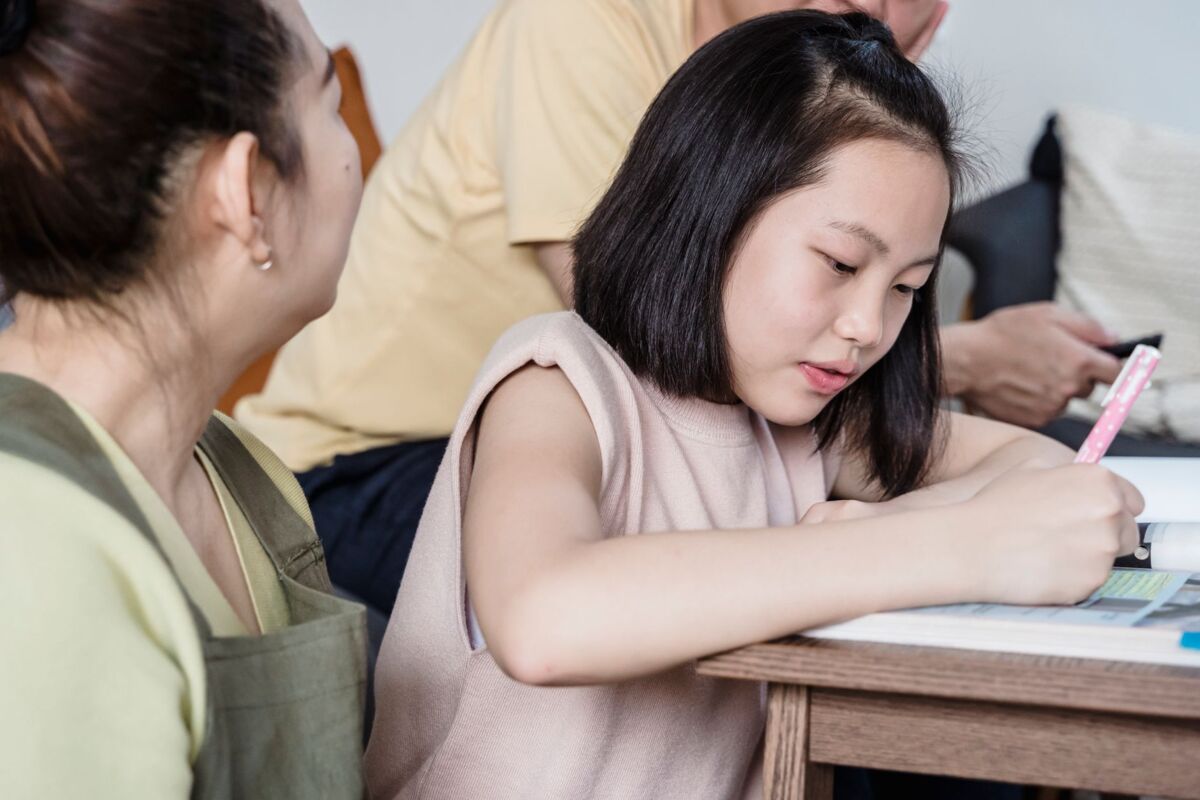 Girl studying at home with family support, focusing on education and togetherness.