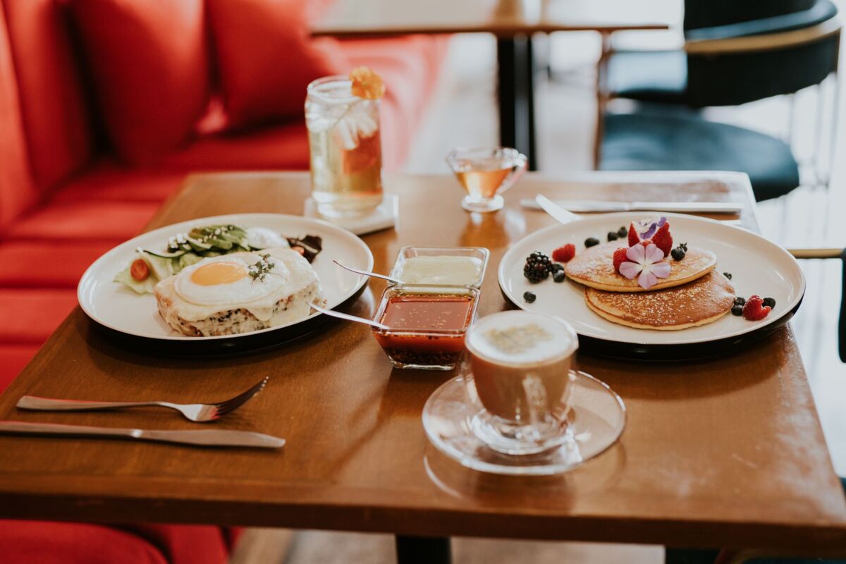 A mouth-watering breakfast spread featuring pancakes, eggs, and coffee in a cozy cafe setting.