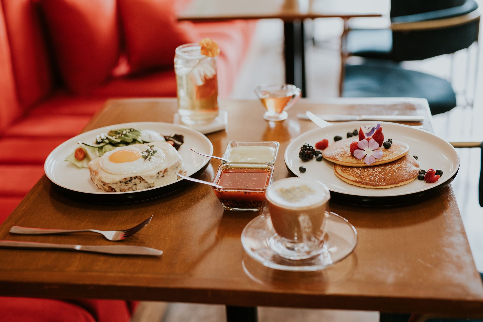 A mouth-watering breakfast spread featuring pancakes, eggs, and coffee in a cozy cafe setting.