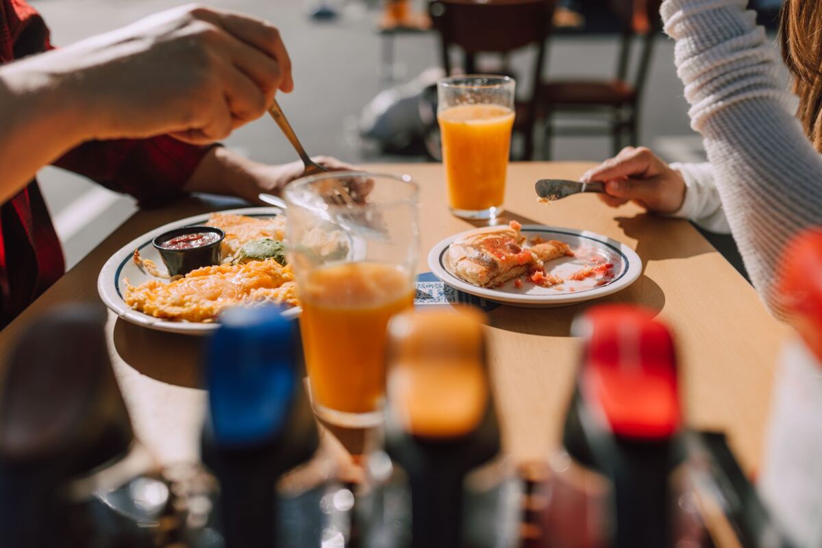 Enjoy a breakfast with pancakes and orange juice in a cozy outdoor setting.