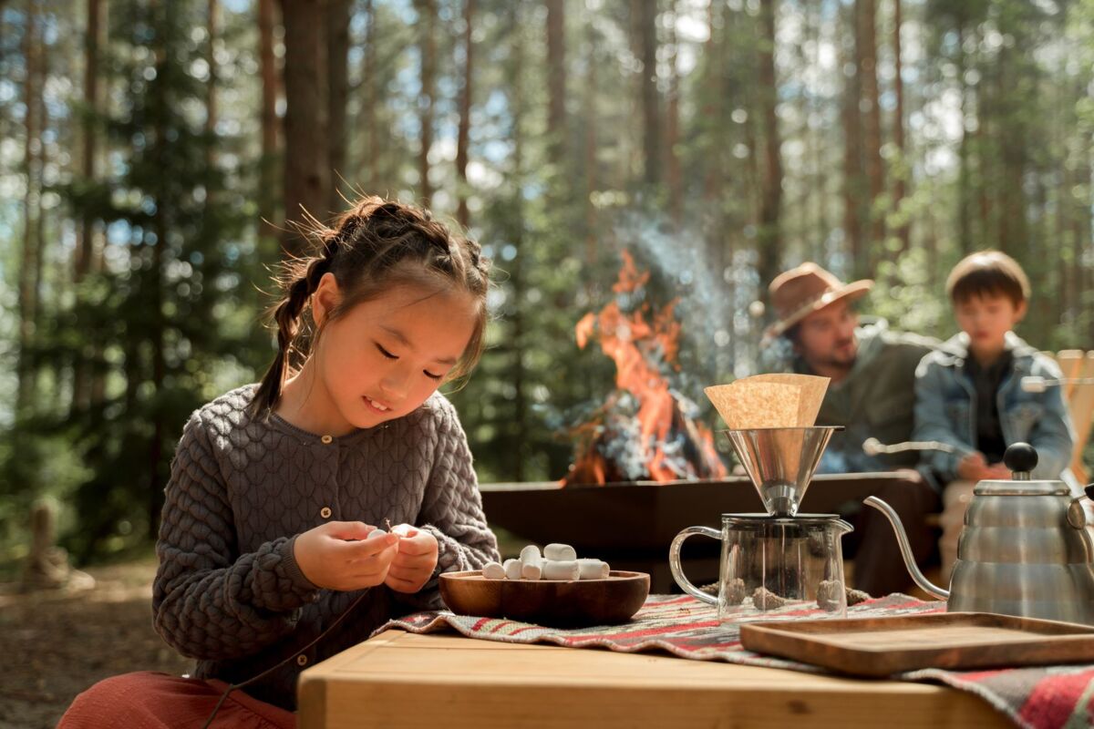 A young girl with marshmallows at a cozy outdoor camping scene by the campfire.