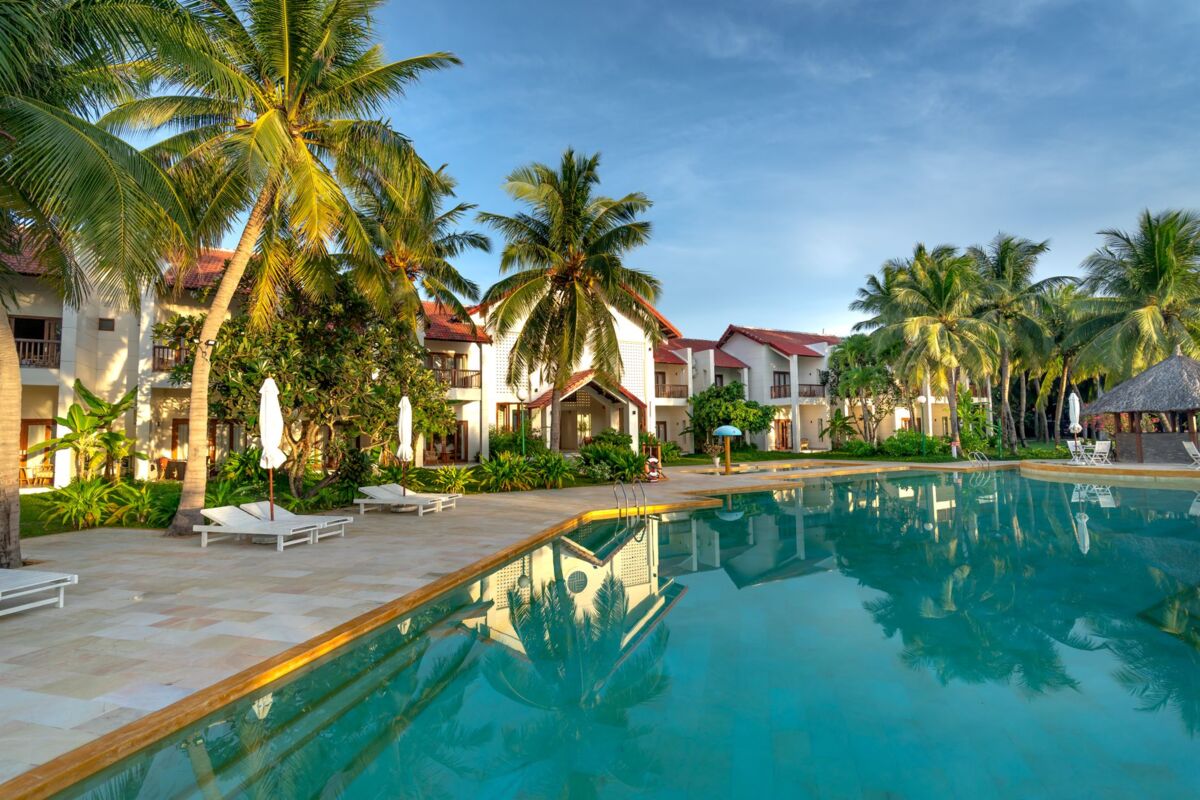 Luxury resort poolside view with palm trees, offering a tropical and serene escape.