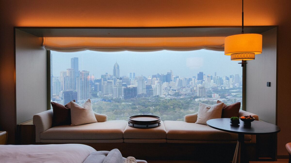 Elegant hotel room view overlooking the stunning Bangkok skyline during the day.