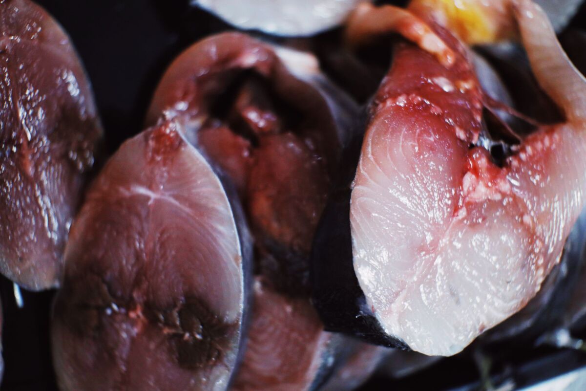 From above of raw fresh sliced fish with blood placed in heap in daytime