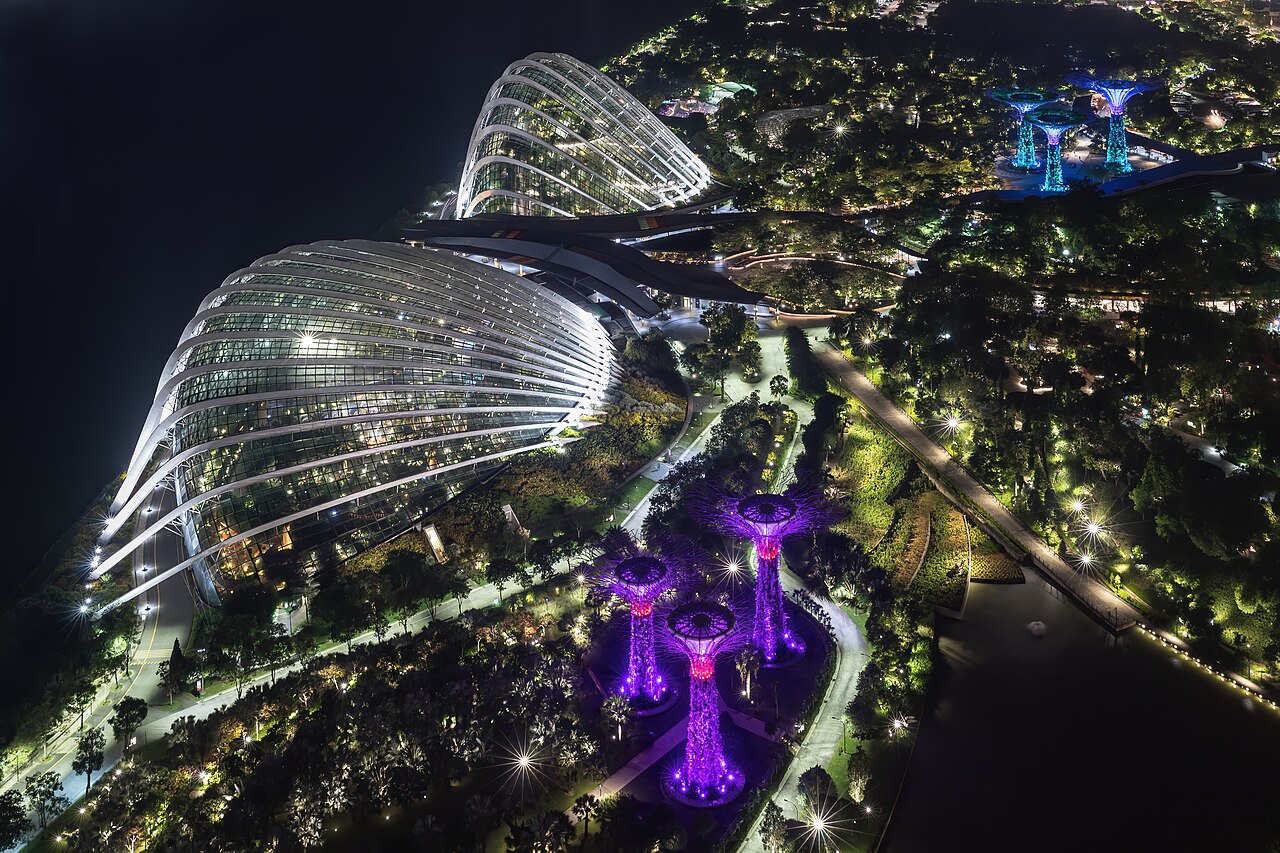 Aerial night view of Gardens by the Bay with the glass conservatory domes and Supertrees glowing purple