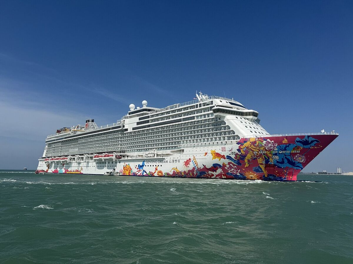 Genting Dream cruise ship at sea under a clear blue sky, showing its colourful painted bow artwork