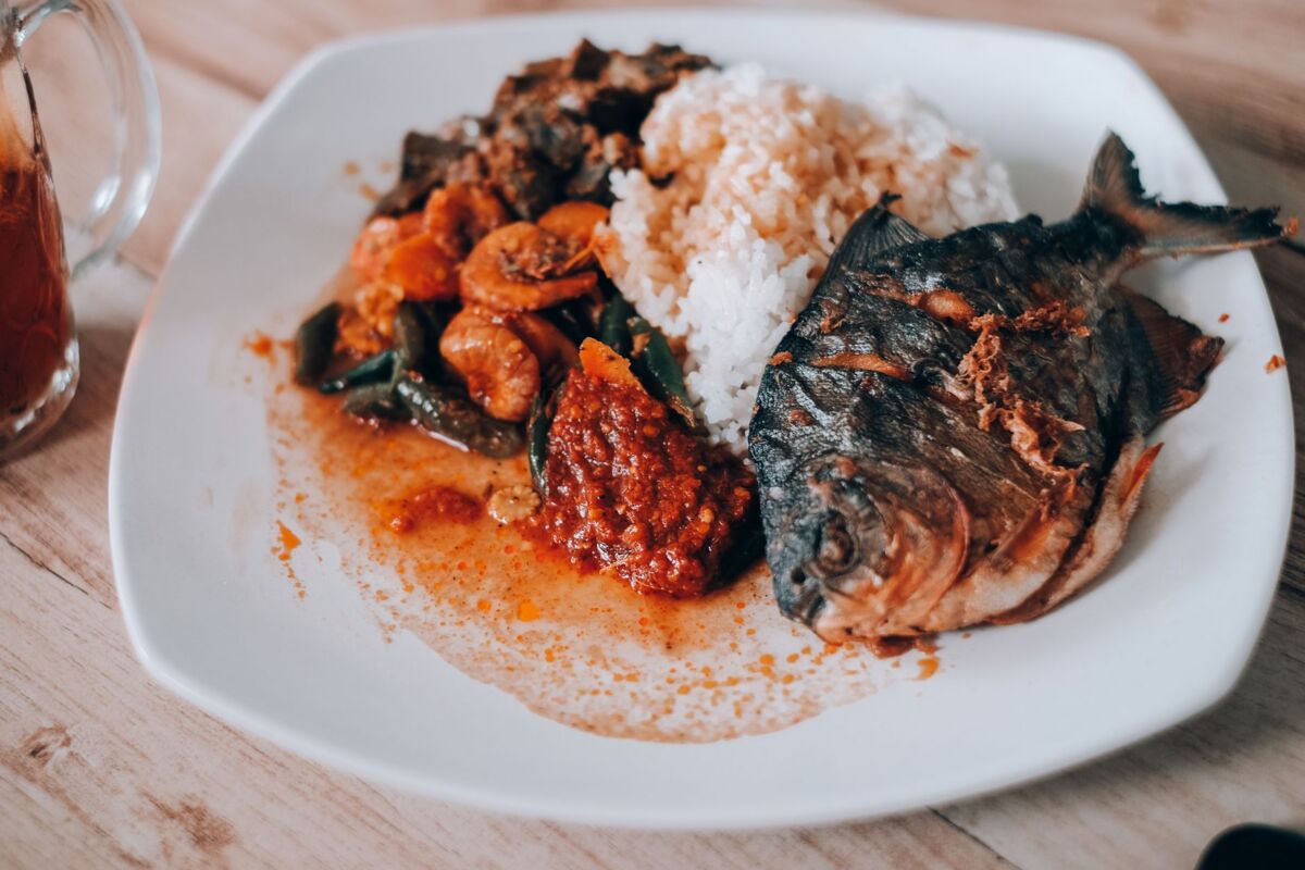 Delicious plate of Nasi Campur with fried fish, rice, shrimp, and sambal.