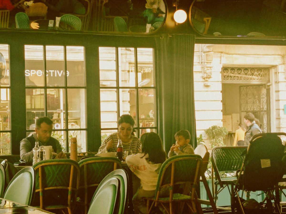 A family shares a meal in a charming cafe, enjoying quality time together.