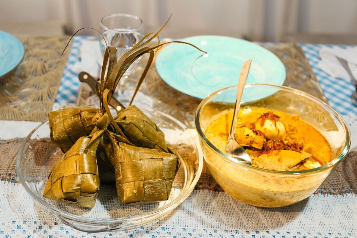 Delicious Malaysian ketupat and spicy chicken curry served in bowls, ready for a traditional meal.