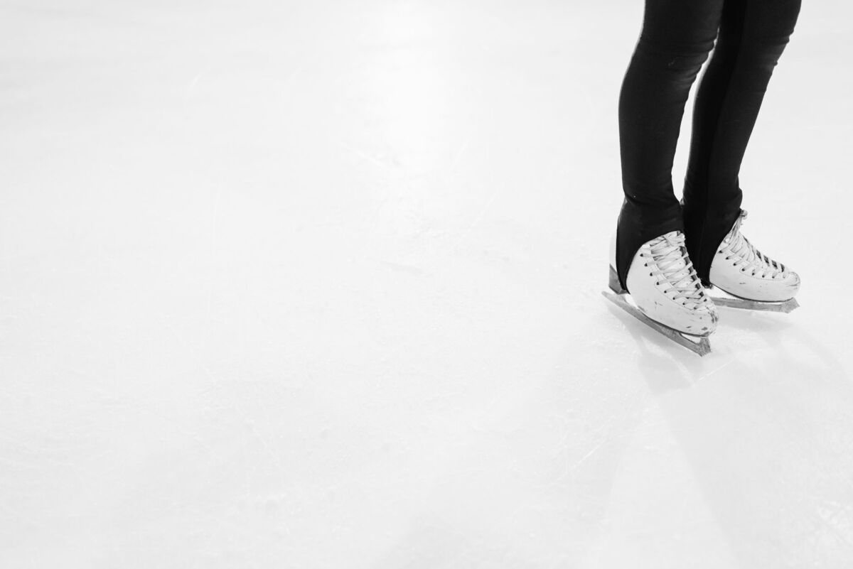 White ice skates on a clean ice rink, perfect for winter sports or skating themes.