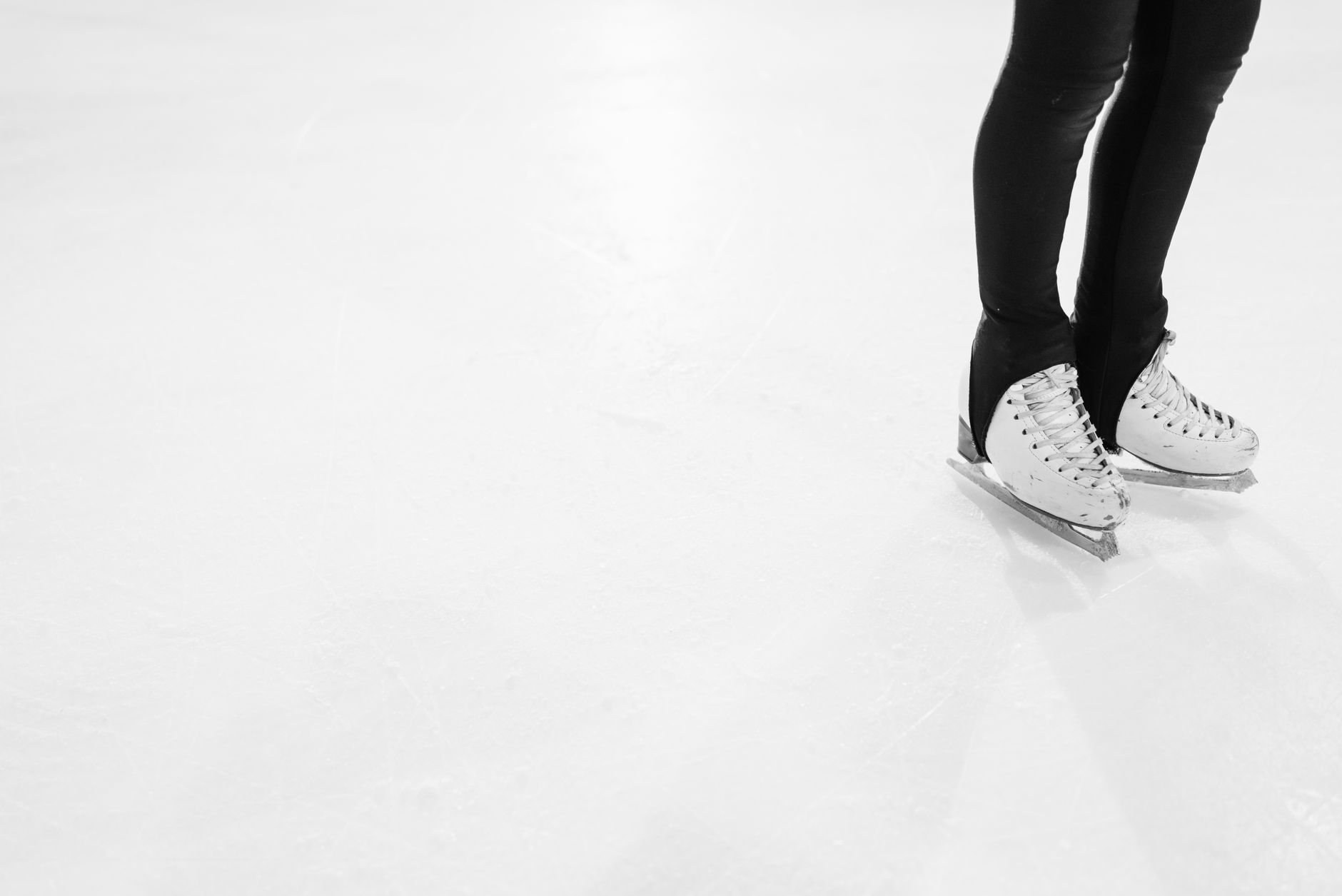 White ice skates on a clean ice rink, perfect for winter sports or skating themes.