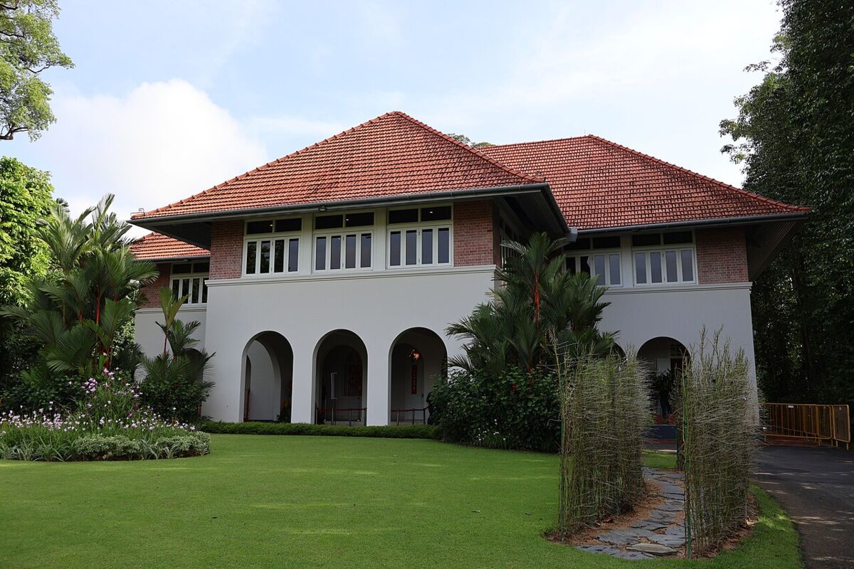 The Villa at the Istana, a red-roofed colonial bungalow with arched verandah and garden lawn