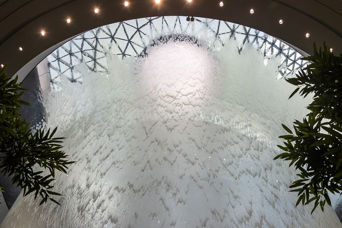 Close-up of the rippling sheet of water flowing down the Rain Vortex beneath the glass dome at Jewel Changi Airport