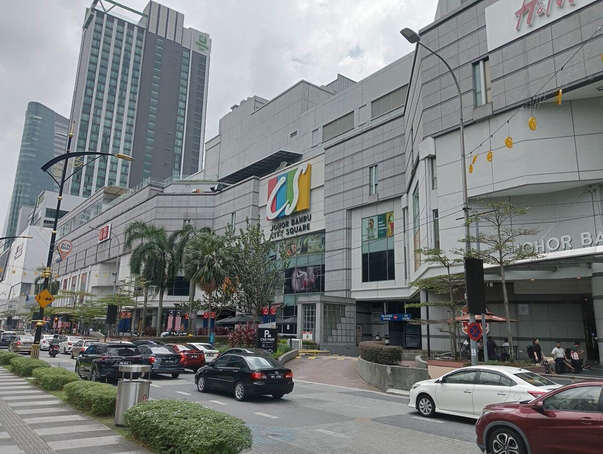 Street view of the Johor Bahru City Square shopping mall exterior with cars and palm trees