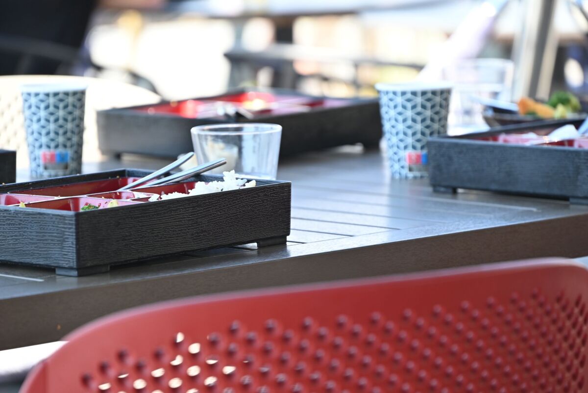 Modern outdoor dining setting with Japanese bento boxes on a table, perfect for casual meals.