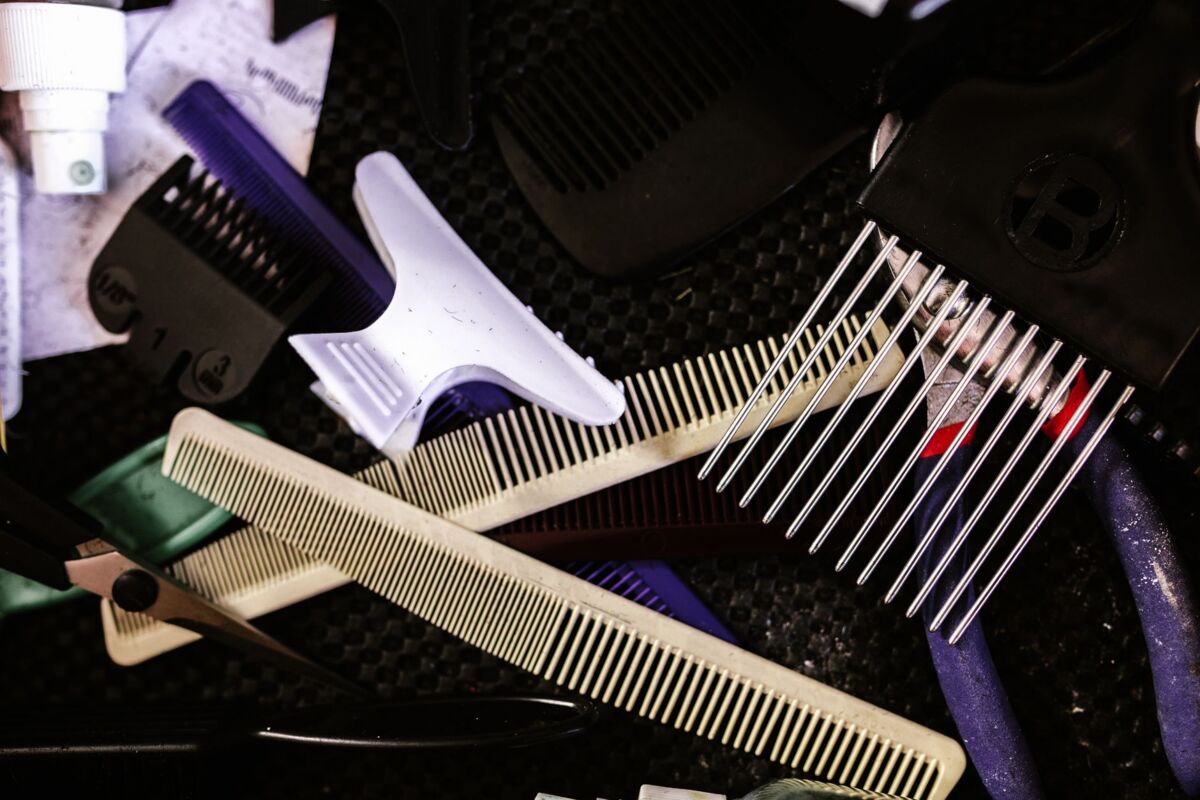 Collection of essential hairdressing tools including combs, clips, and scissors for salon use.