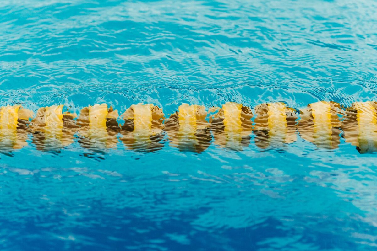 Close-up of yellow lane marker floating in a blue swimming pool, vibrant and refreshing.