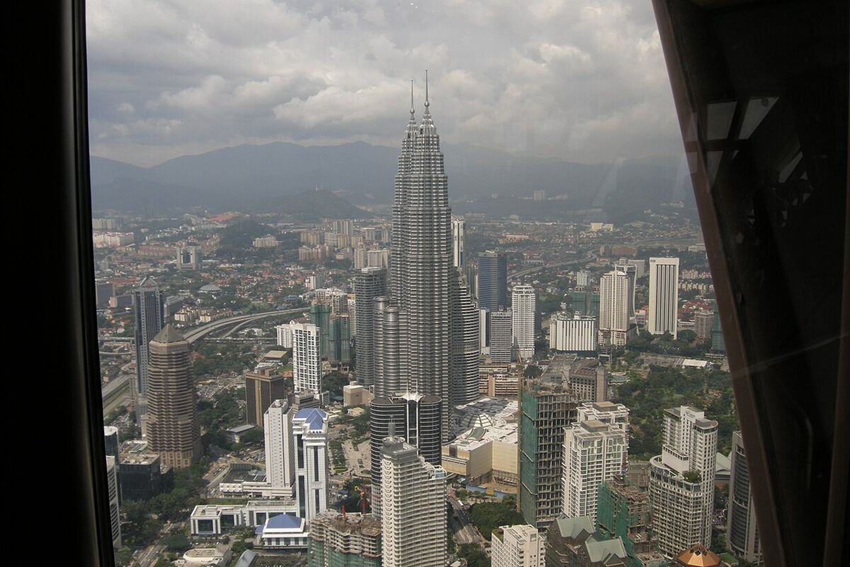 Aerial view of the Petronas Towers rising above the sprawling Kuala Lumpur cityscape seen from KL Tower