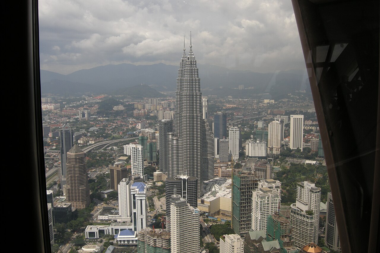 Aerial view of the Petronas Towers rising above the sprawling Kuala Lumpur cityscape seen from KL Tower