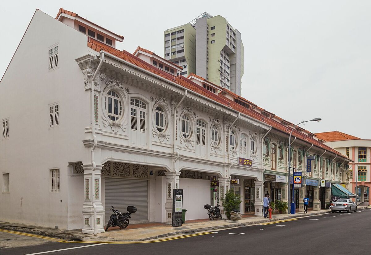Restored white heritage shophouses with ornate facades and red-tiled roofs along Syed Alwi Road in Little India, Singapore