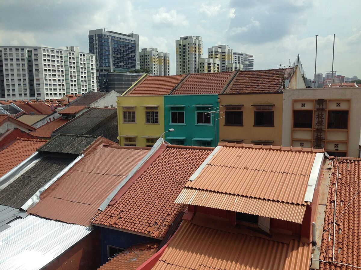 Red-tiled rooftops of Little India shophouses along Campbell Lane with colourful upper storeys and high-rise buildings behind