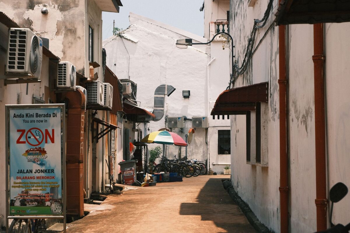An inviting alleyway with bicycles and umbrellas in Malacca, Malaysia.