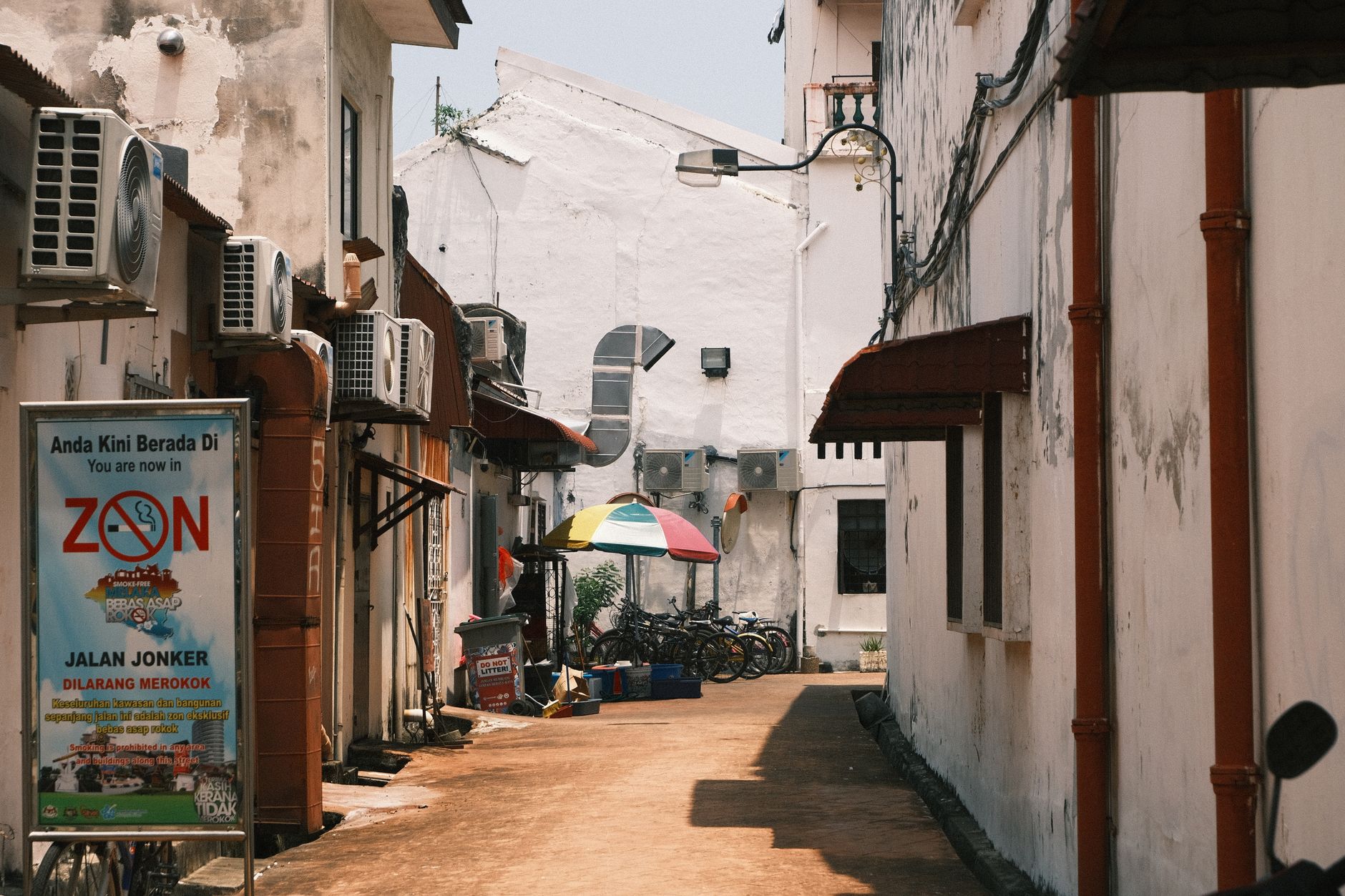An inviting alleyway with bicycles and umbrellas in Malacca, Malaysia.