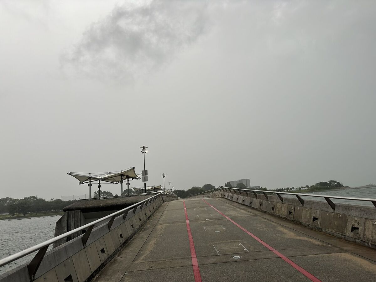The broad walkway across the top of Marina Barrage with the reservoir on one side and the sea on the other