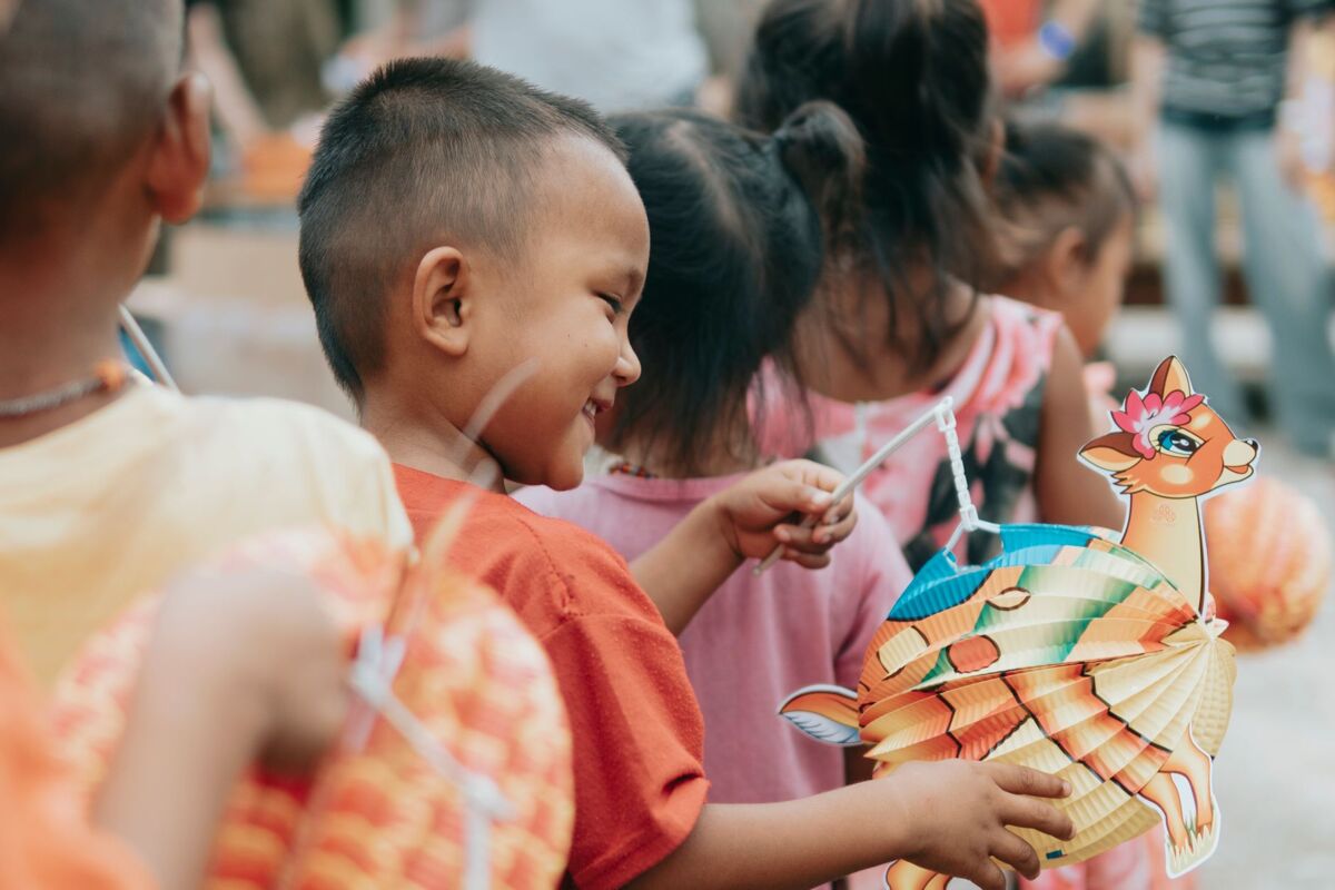 Children delighting in a festive celebration holding colorful animal-shaped lanterns outdoors.