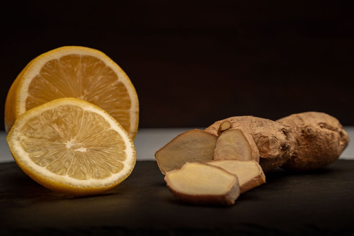 Close-up of fresh ginger root and lemon slices, highlighting their vibrant natural textures and health benefits.