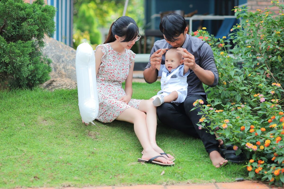 Asian family enjoying quality time with their baby in a garden setting.