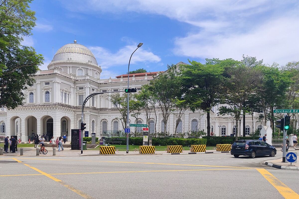 The National Museum of Singapore seen from Orchard Road under a blue sky with visitors outside